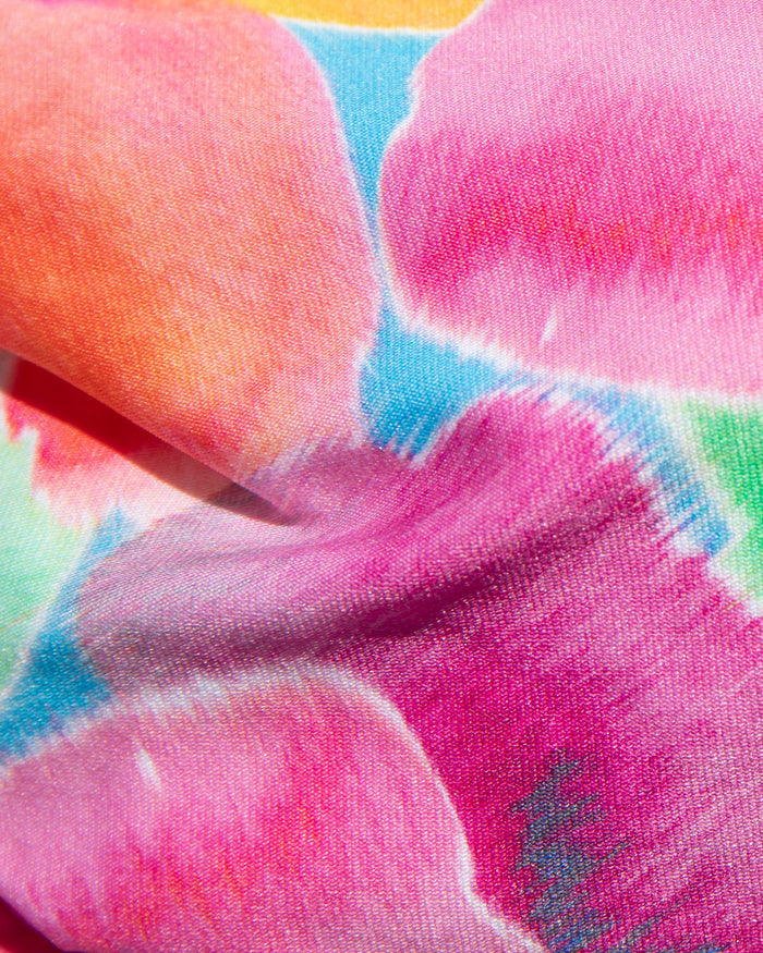 Close-up of pink, orange, blue, and teal floral print fabric used in the LSPACE Flower Play Donnie Bikini Bottom.