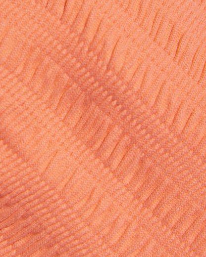 Close-up detail of the Fresh Squeezed fabric texture of the LSPACE Leilani Bikini Bottom, showing the peach-orange ribbed swimwear material.