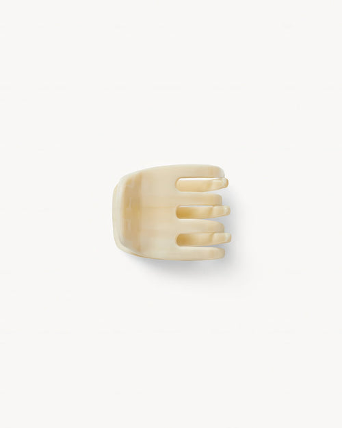 Off-model top-down view of the Machete Mini Claw in alabaster showing the teeth and solid cream acetate.