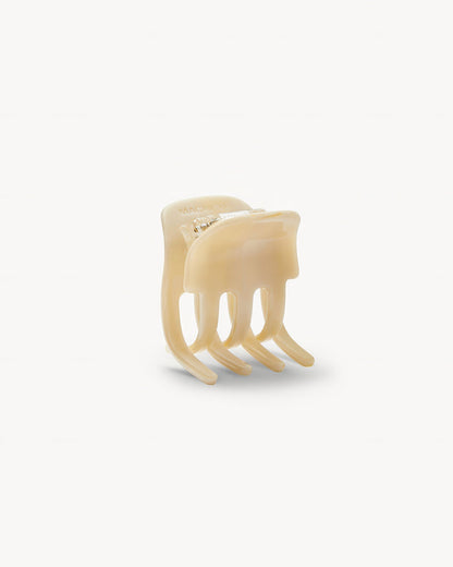 Off-model open detail view of the Machete Mini Claw in alabaster showing the teeth and cream acetate construction.