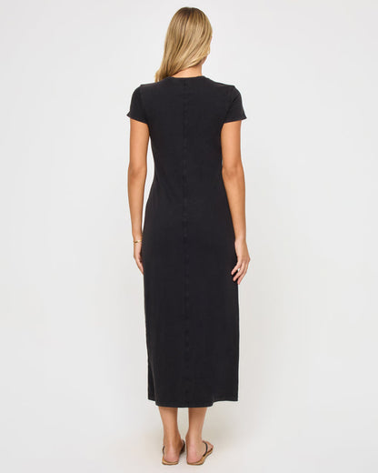 Back view of a model wearing the LSPACE Sloane Dress in black, showing the clean fitted back of the maxi dress with short sleeves.