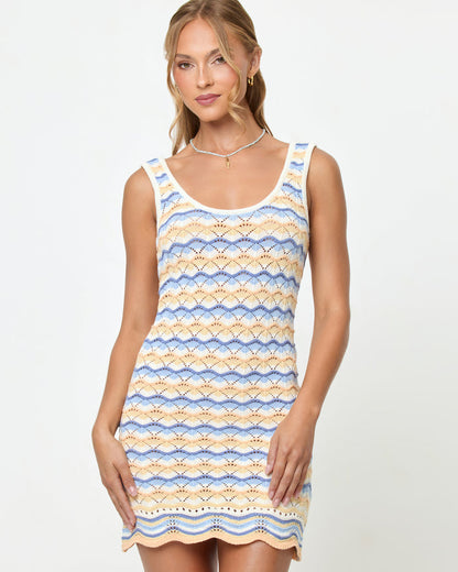 Front view on model of the LSPACE Sunchaser Dress in Daydreamer, a sleeveless crochet mini dress in a blue, peach, and white scallop pattern, shown from the waist up.